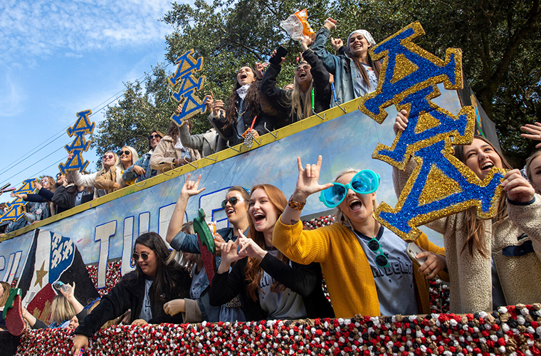 delta delta delta sorority members cheer on their homecoming float