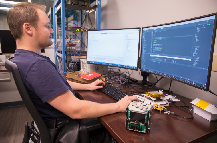 UL Lafayette student works at computer with dual monitors