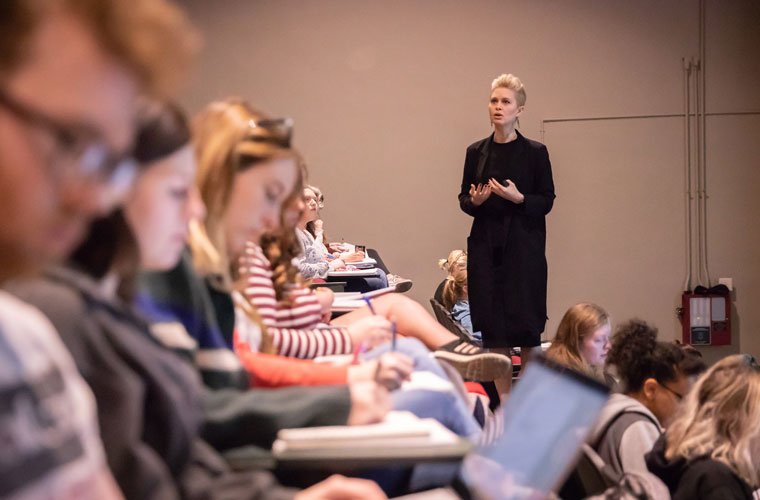 A University of Louisiana at Lafayette faculty member speaking to a room full of students 