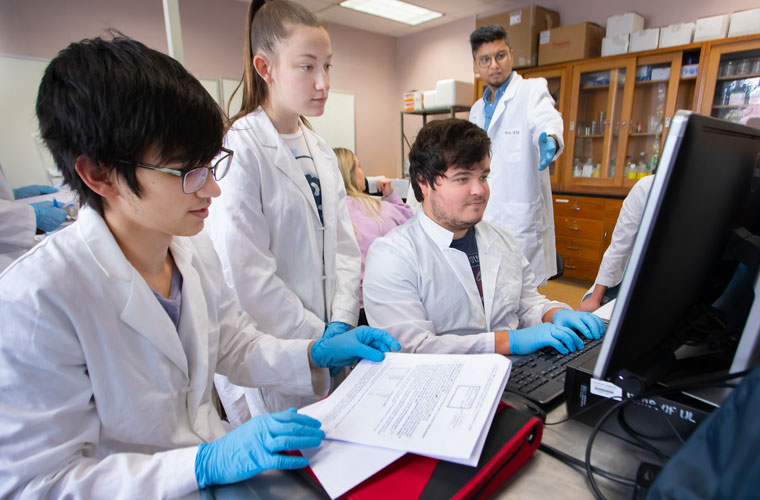 Physics students at the University of Louisiana at Lafayette looking at a computer together