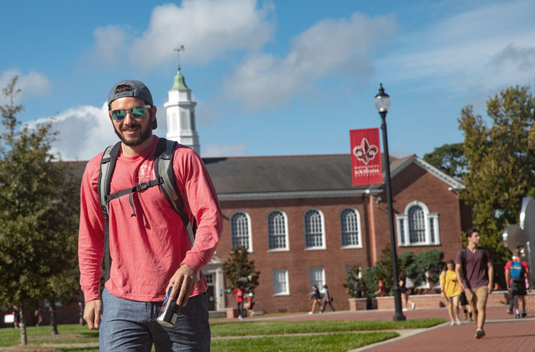A University of Louisiana at Lafayette student walking in front of Stephens Hall
