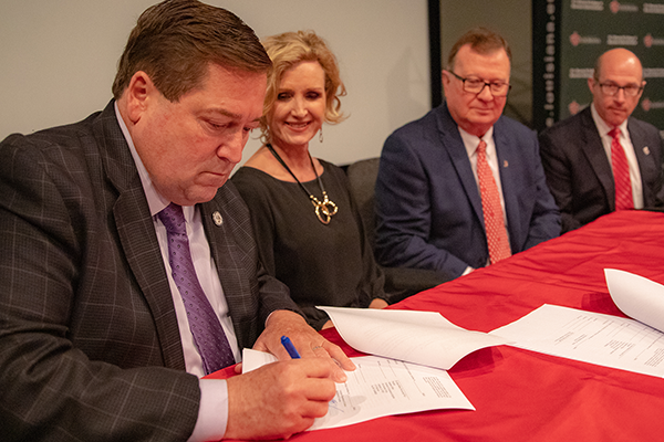 Lt. Gov. Billy Nungesser signs grant papers, seated by, from left to right: Dr. Carrie Castille, Dr. Joseph Savoie, and Dr. Jaimie Hebert.