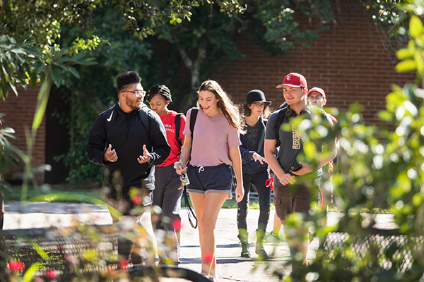 A group of 6 students walking through the UL Lafayette campus