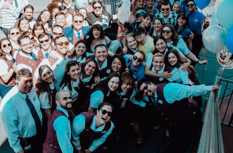 Hospitality Management alum Madeleine Comeaux from the University of Louisiana at Lafayette taking a group photo with her Disney coworkers.