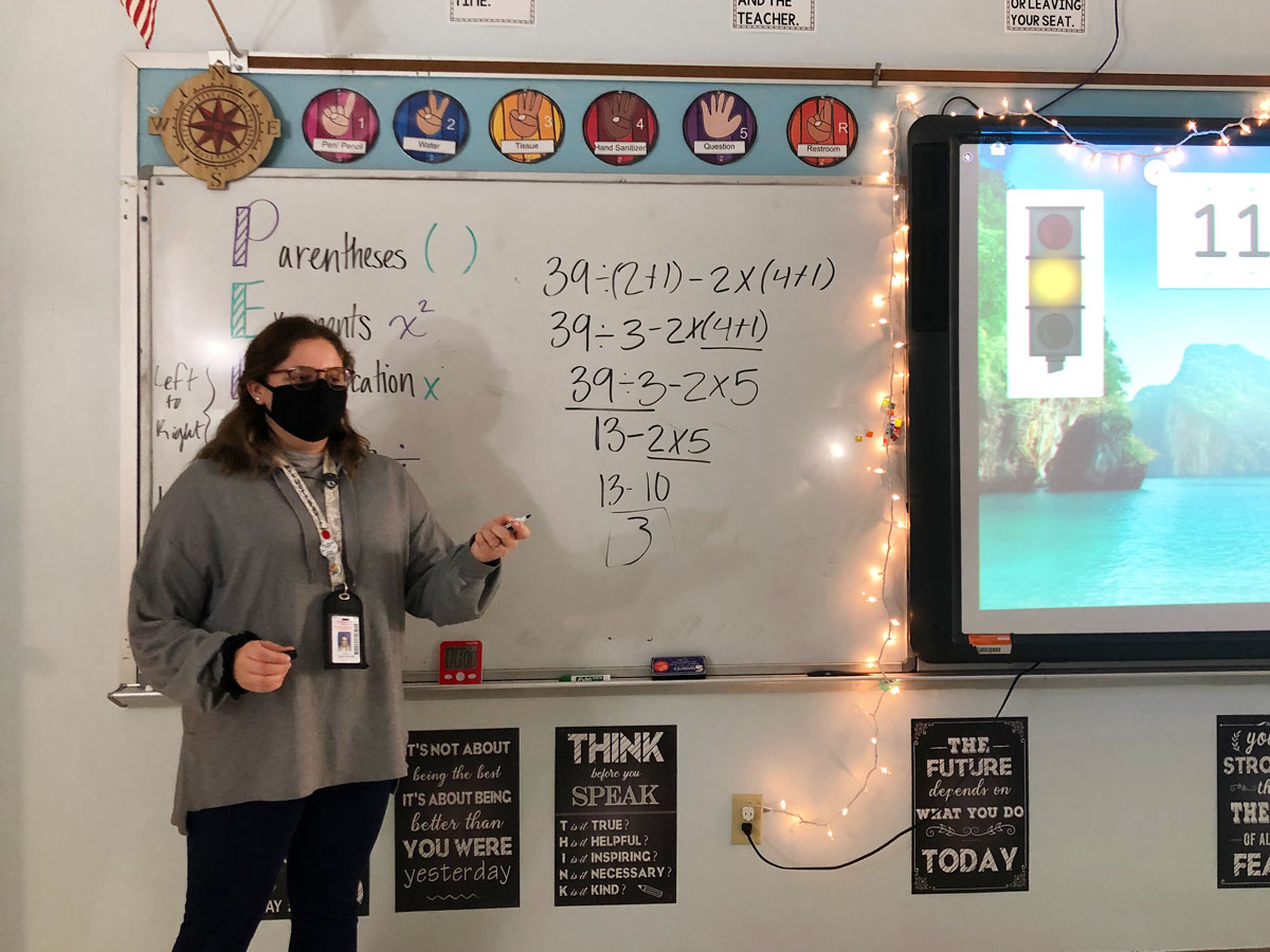 Education major Malani Hoffpauir stands in front of a white board in her classroom