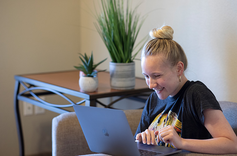 UL Lafayette online student working at her laptop.