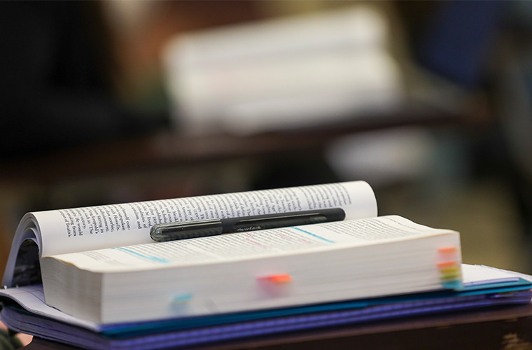 A textbook with tabs and a pen
