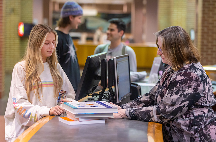 UL Lafayette student checking out books from Edith Garland Dupre Library.