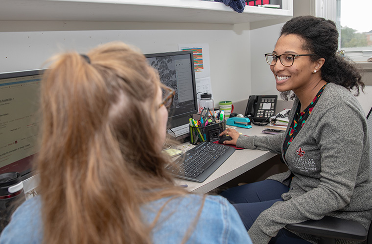 A member of the Learning Center talking with a UL Lafayette student.