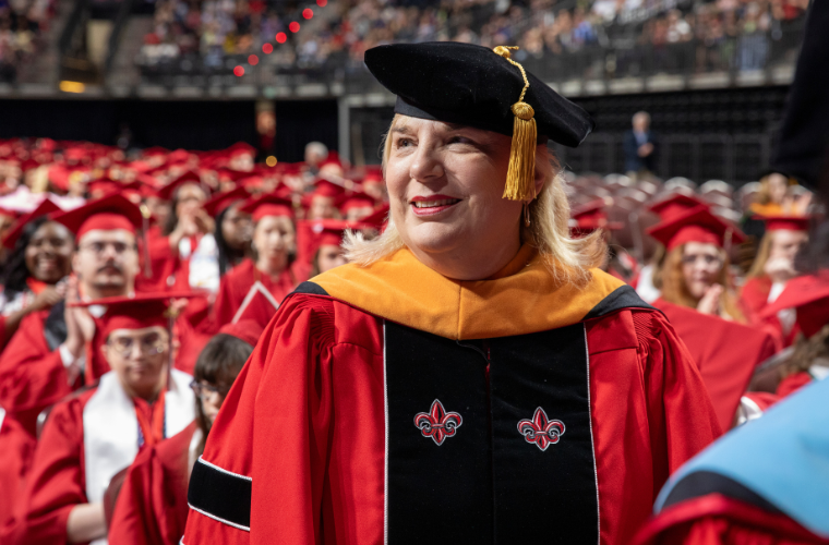 UL Lafayette DNP graduate smiles while gazing into the Commencement crowd.