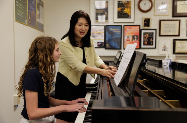 Teacher teaching student piano