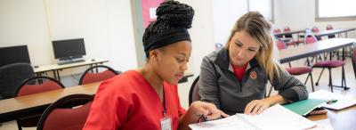 One UL Lafayette student tutoring another a campus classroom