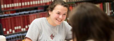 A University of Louisiana at Lafayette student smiling and laughing with a classmate while studying
