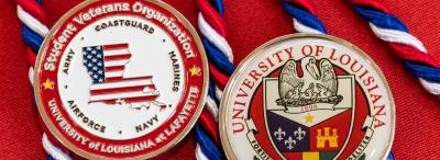 Two University of Louisiana at Lafayette medals on red background, left medal of the Student Veterans Organization, right medal of University crest