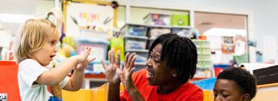Child Development administrator engages with young child