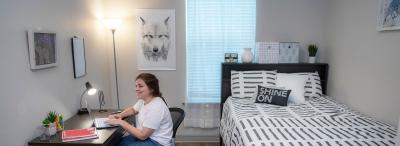 student at laptop in dorm room