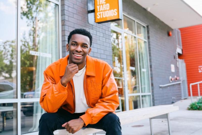 Online general studies grad Cameron Theyard smiles in front of his office space, The Yard Studios.