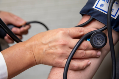 Alumna of the UL Lafayette RN to BSN online program takes a patients blood pressure.