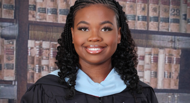 Masters in Gifted Education graduate smiles for portrait in black UL Lafayette master's regelia. 