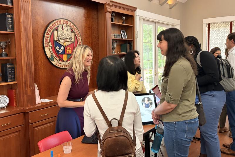 Three women are pictured around a table presentation during the 2026 FLC Showcase.